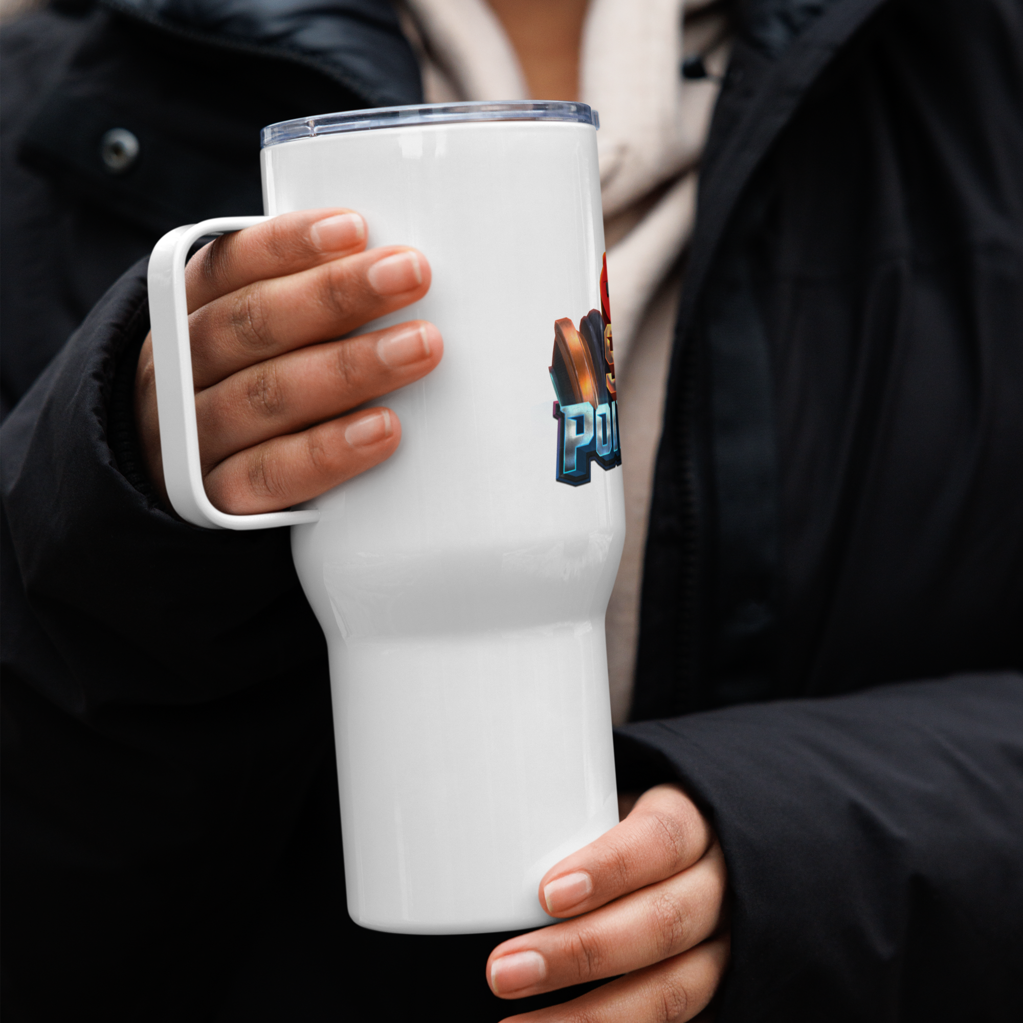 Person holding a white travel mug with handle, featuring a colorful design, perfect for commuting and adventures.