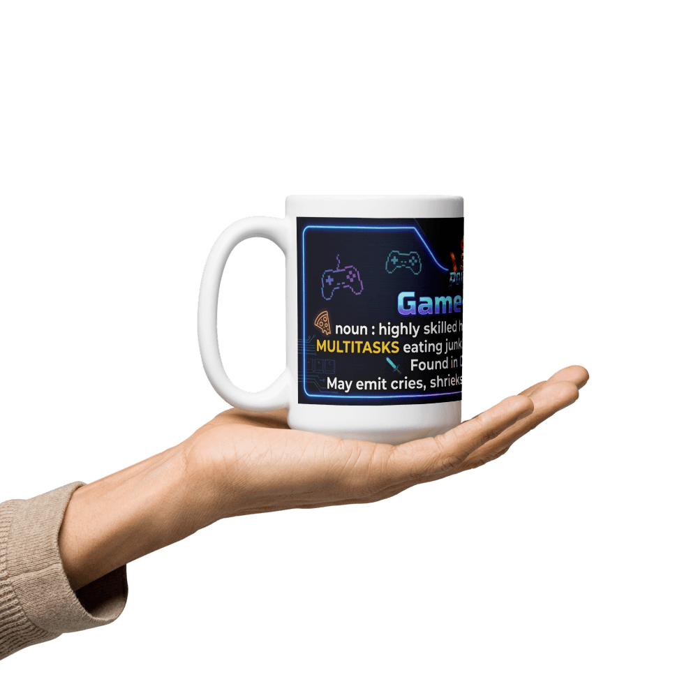 White glossy gamer coffee mug held in hand, featuring humorous gaming definitions and vibrant design.