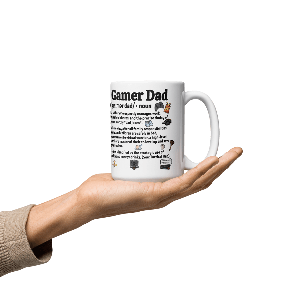 Gamer Dad Coffee Mug held in hand, featuring fun definitions and gaming graphics on a glossy ceramic surface.