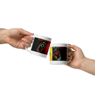 Two hands clinking ceramic mugs with "Player 1" and "Player 2" gaming controller designs, showcasing a sturdy, glossy finish.